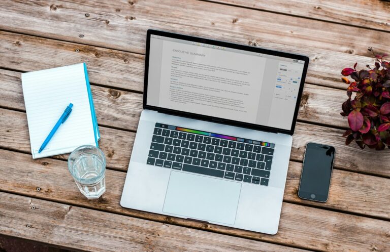 Mesa com notebook e anotações para planejar um aplicativo antes de programar